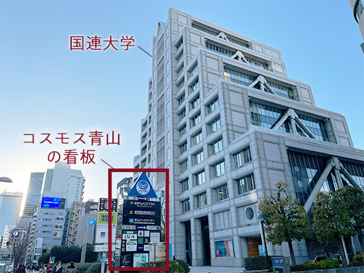 B2出口を出て、青山通りを渋谷方面に直進すると右手に国連大学があり、その手前には「コスモス青山」の看板があります。